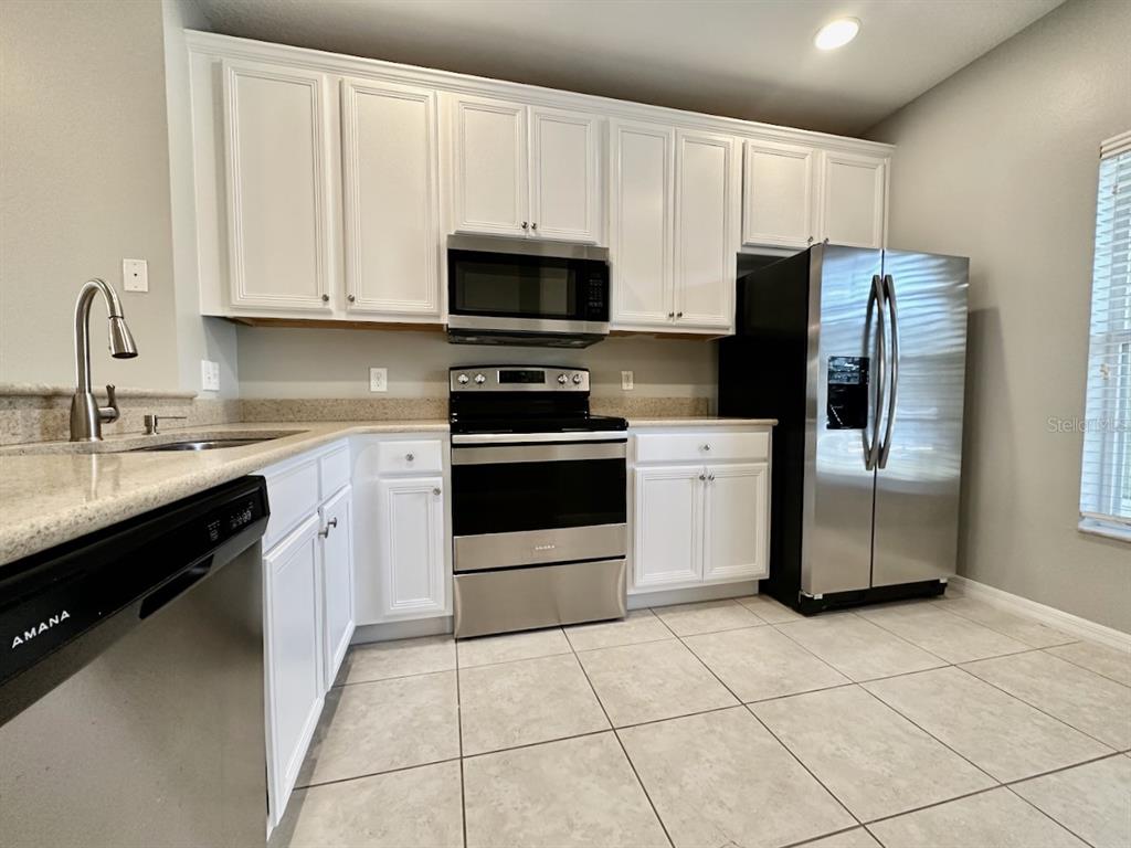 8532 Brushleaf Way Tampa, FL 33647 - Photo 3 of 20 a kitchen with stainless steel appliances granite countertop a stove a sink and a refrigerator