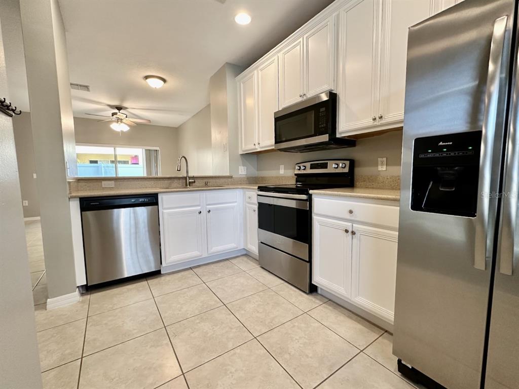 8532 Brushleaf Way Tampa, FL 33647 - Photo 4 of 20 a kitchen with stainless steel appliances granite countertop a refrigerator sink and white cabinets