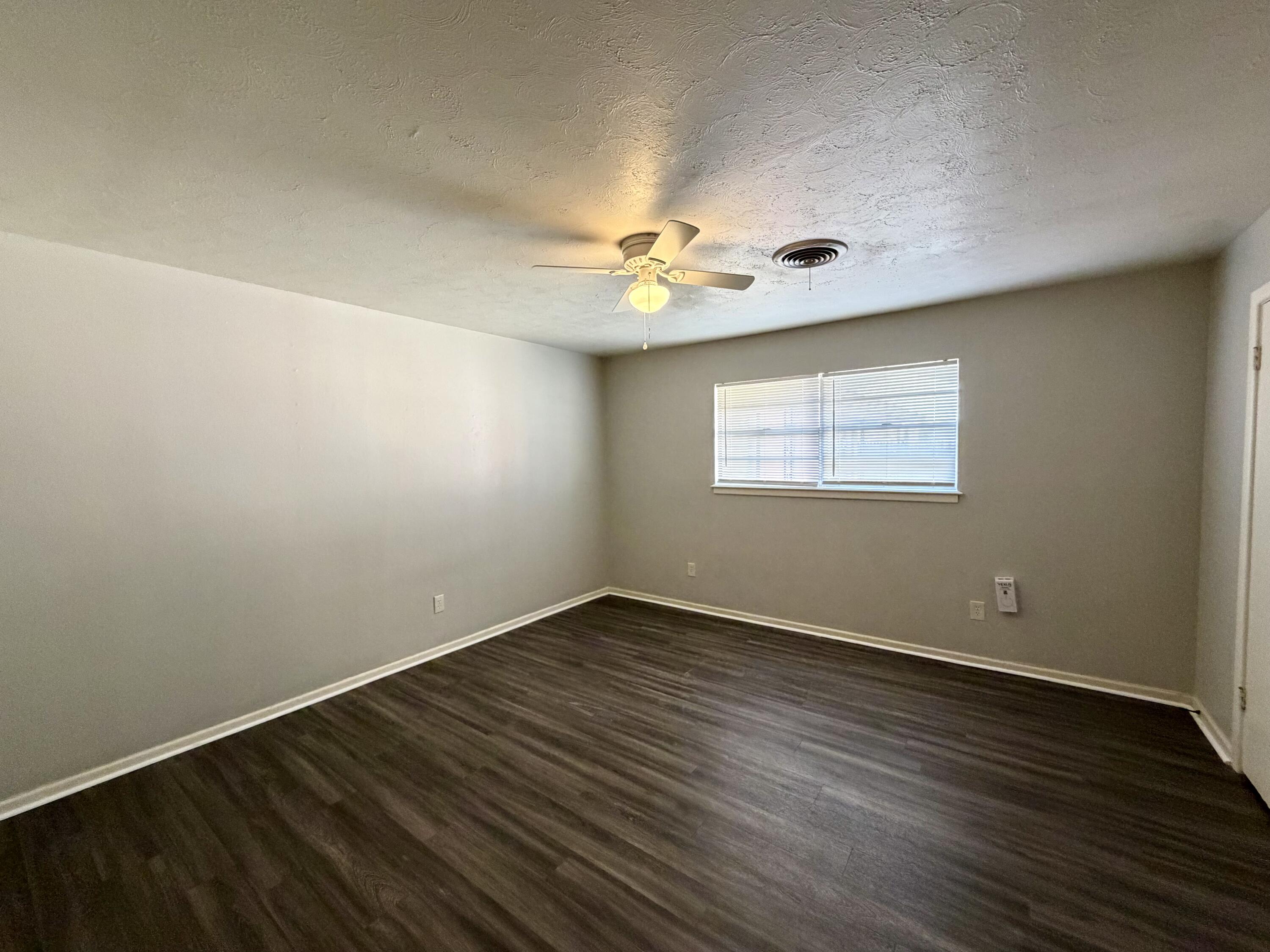 3813 51st Street, Unit A Lubbock, TX 79413 - Photo 11 of 17 an empty room with wooden floor and windows