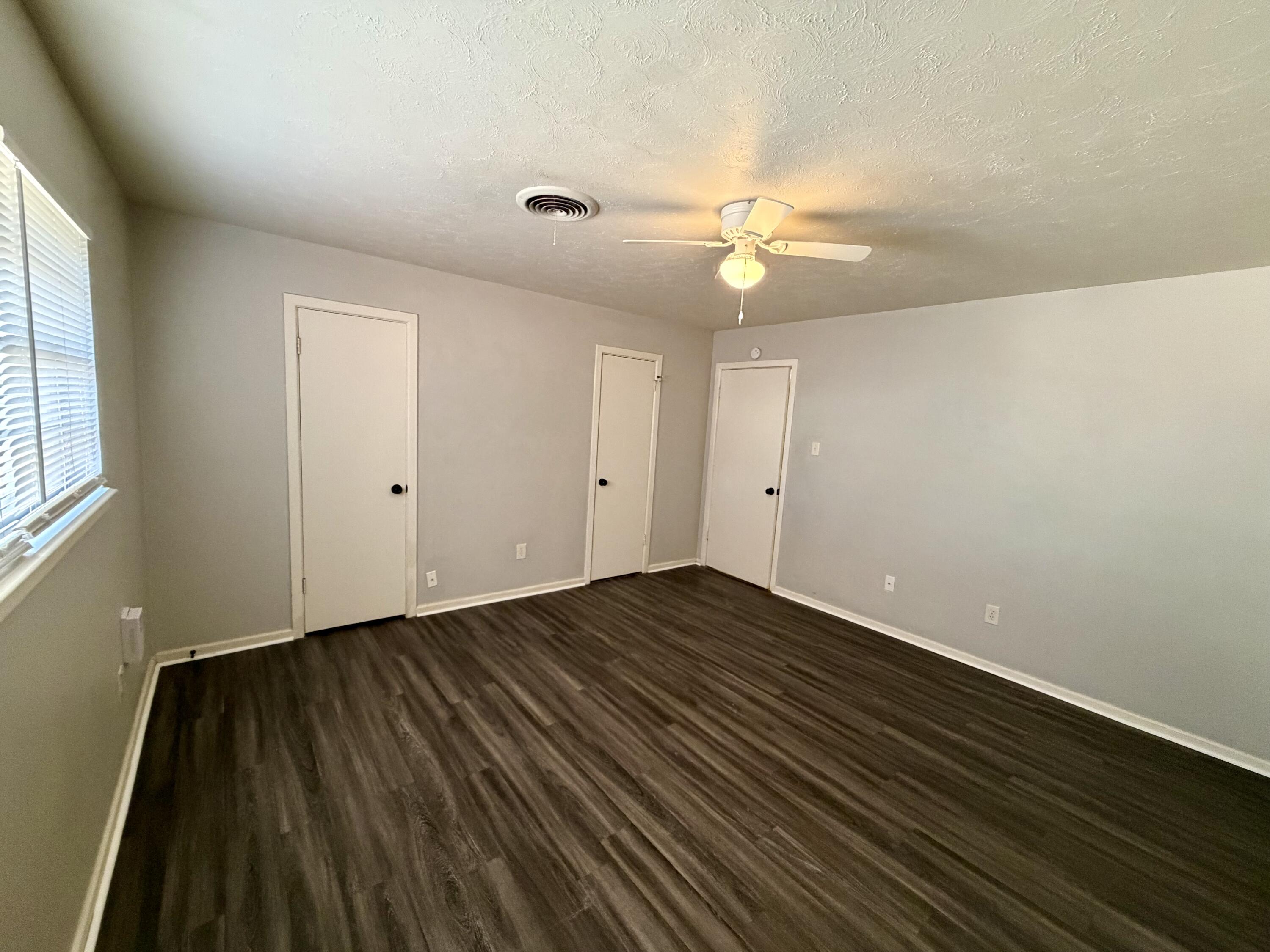 3813 51st Street, Unit A Lubbock, TX 79413 - Photo 12 of 17 wooden floor in an empty room with a window