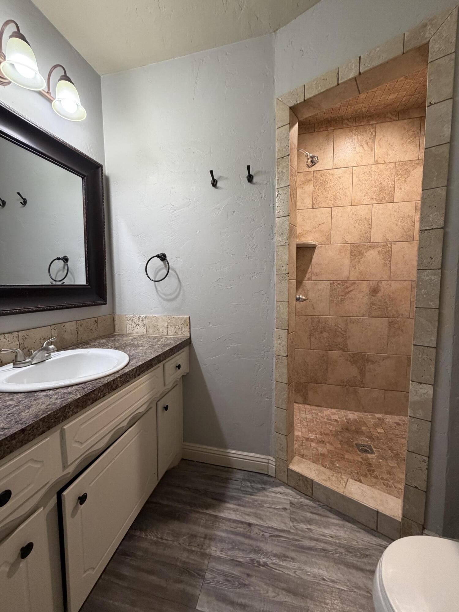 3813 51st Street, Unit A Lubbock, TX 79413 - Photo 13 of 17 a bathroom with a granite countertop sink toilet and shower