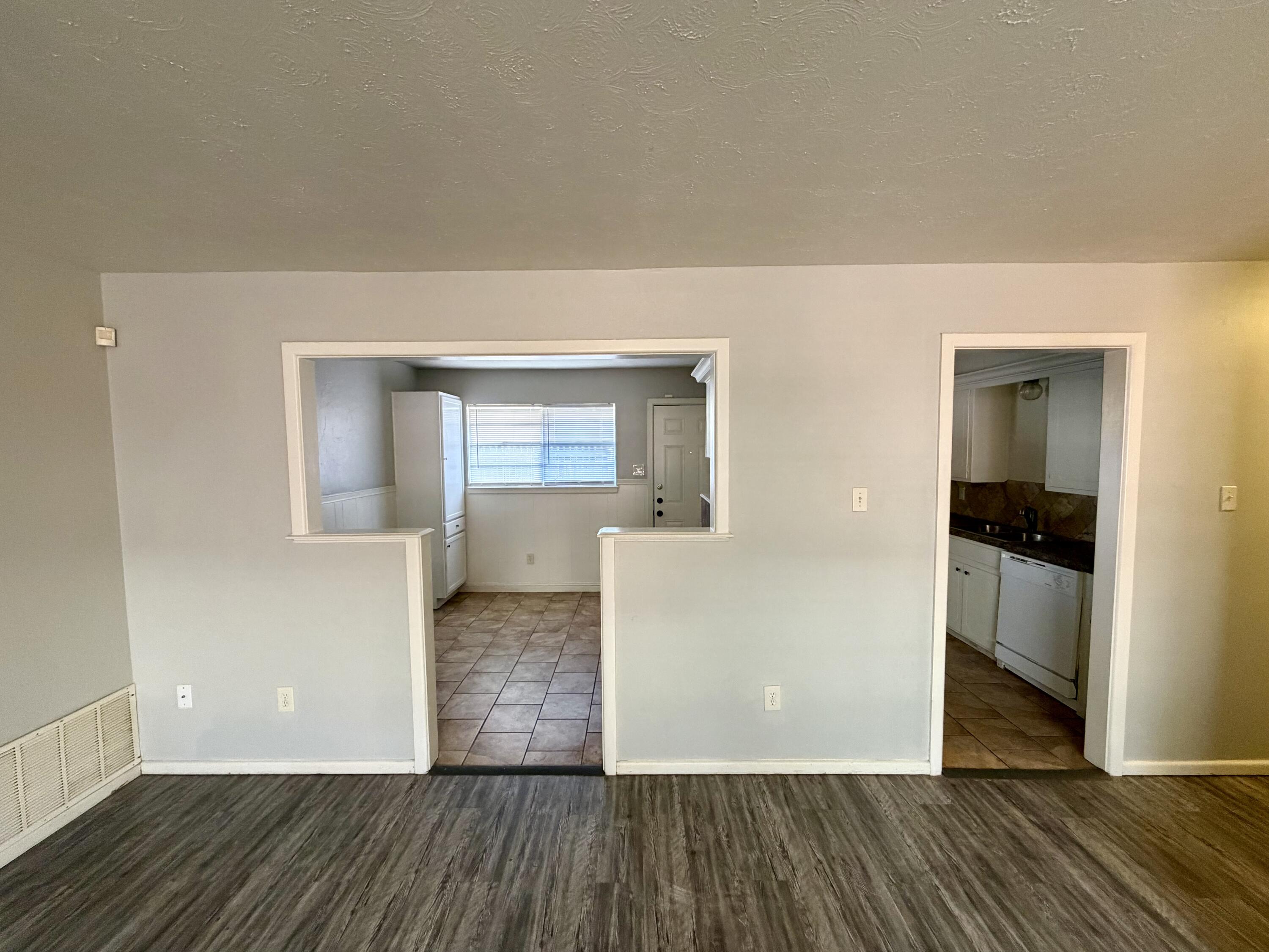 3813 51st Street, Unit A Lubbock, TX 79413 - Photo 5 of 17 a view of a livingroom with wooden floor and kitchen