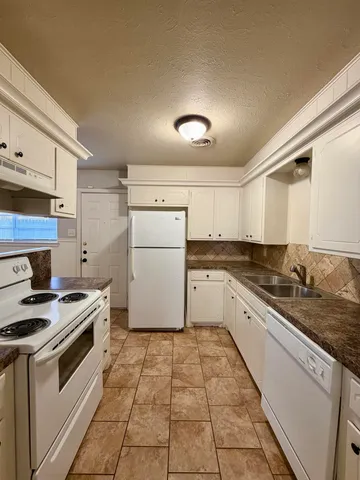 a kitchen with stainless steel appliances granite countertop a sink stove and cabinets