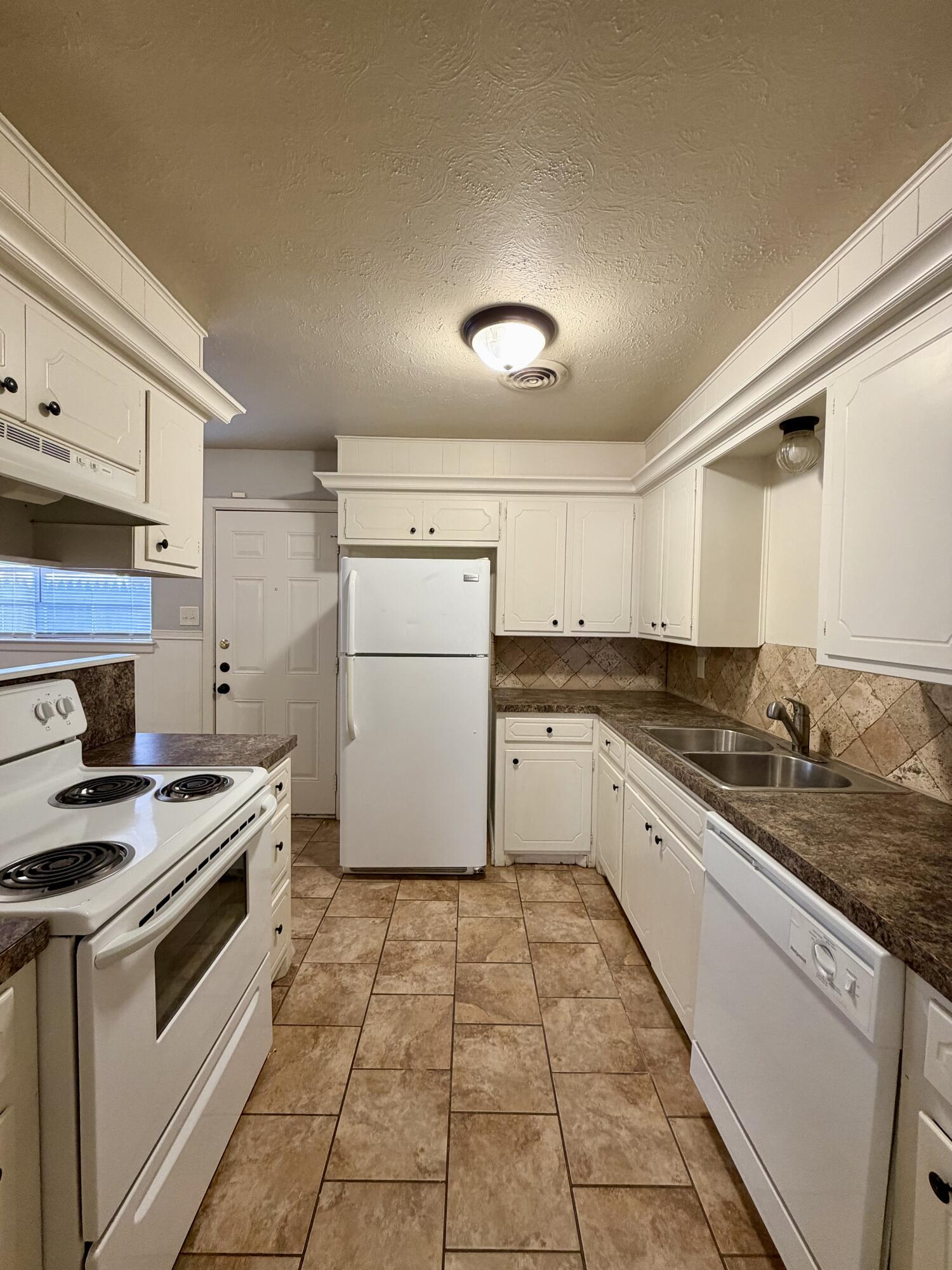 3813 51st Street, Unit A Lubbock, TX 79413 - Photo 6 of 17 a kitchen that has a sink and a stove