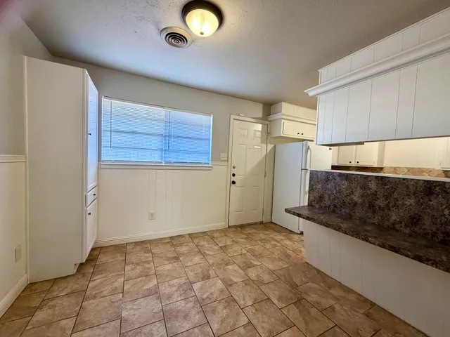 a bathroom with a granite countertop sink a toilet and bathtub