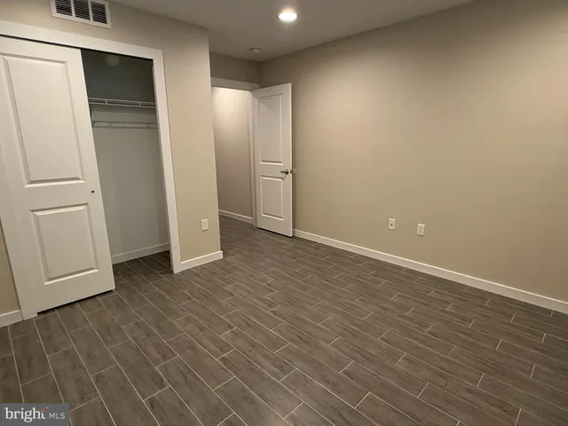 an empty room with wooden floor and closet