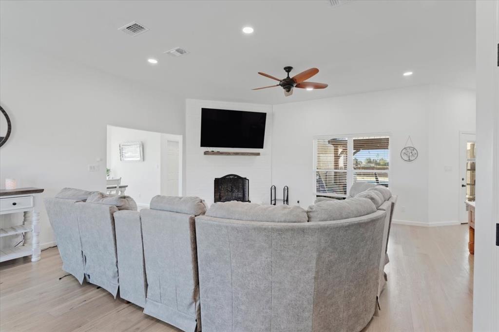 6514 Old Clarksville Road Reno, TX 75462 - Photo 12 of 27 a living room with furniture a flat screen tv and a fireplace