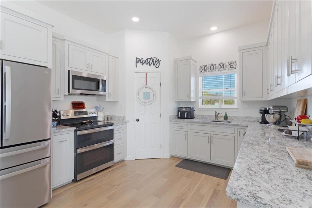6514 Old Clarksville Road Reno, TX 75462 - Photo 14 of 27 a kitchen with a sink stove and refrigerator