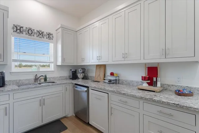 a kitchen with white cabinets and sink