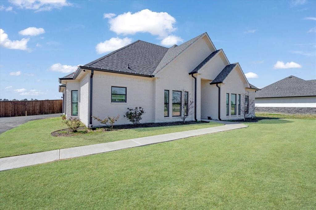 6514 Old Clarksville Road Reno, TX 75462 - Photo 2 of 27 a front view of a house with a garden and yard