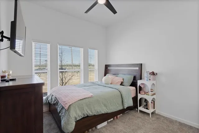 a bedroom with a bed a window and a chandelier