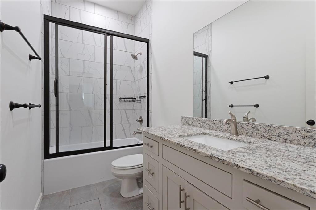 6514 Old Clarksville Road Reno, TX 75462 - Photo 25 of 27 a bathroom with a granite countertop sink toilet and shower