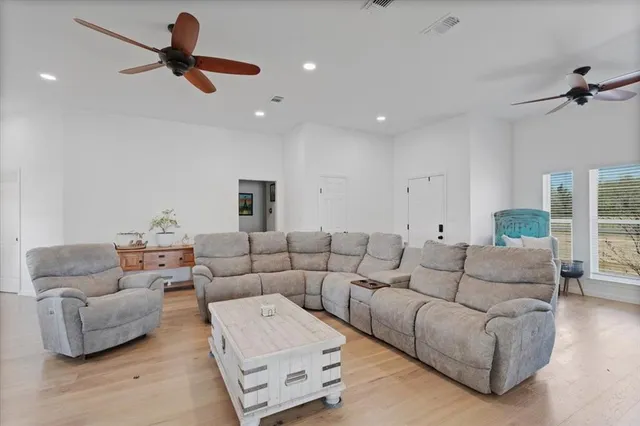 a living room with furniture and a ceiling fan