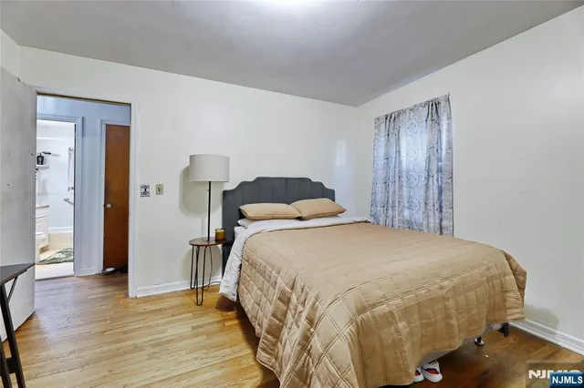 a bedroom with a bed and wooden floor