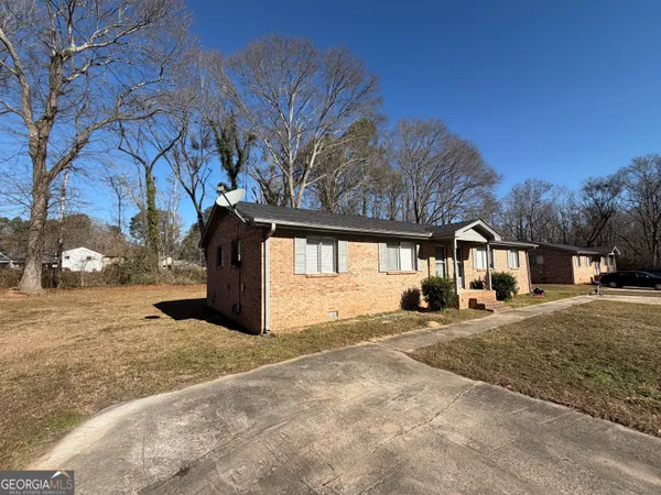 a view of a large white house with a yard covered in snow