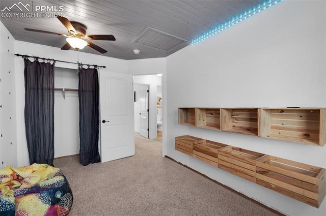 7803 Swiftrun Road Colorado Springs, CO 80920 - Photo 20 of 41 Bedroom with ceiling fan, a closet, and wooden ceiling