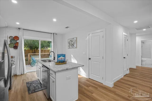 a kitchen with stainless steel appliances granite countertop a refrigerator and a stove top oven