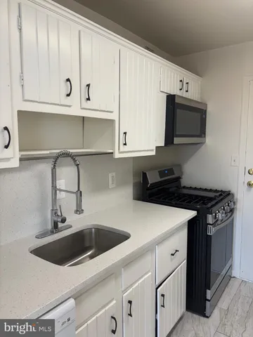 a kitchen with white cabinets and a stove top oven