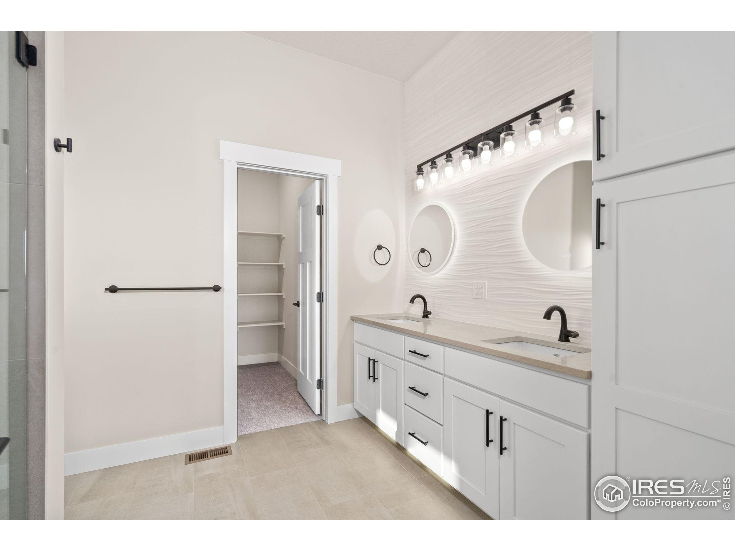 1369 Burt Avenue Berthoud, CO 80513 - Photo 18 of 41 a bathroom with a double vanity sink and mirror