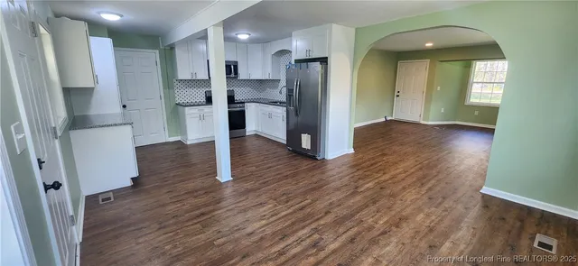 a kitchen with granite countertop a refrigerator stove and sink