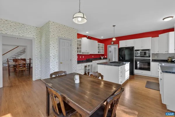 a kitchen with a table chairs microwave and cabinets