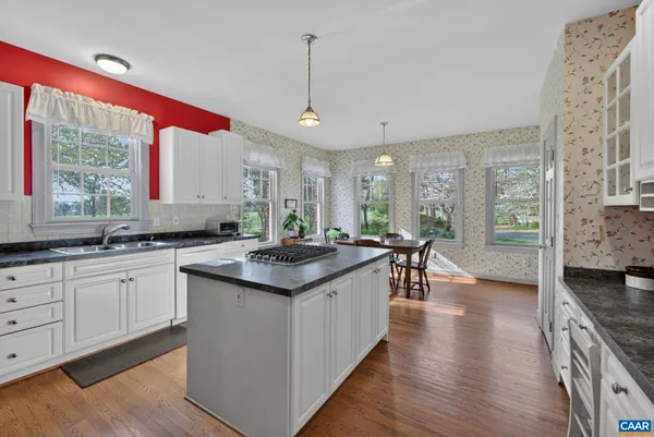 a kitchen with stainless steel appliances granite countertop a sink a stove and a wooden floors