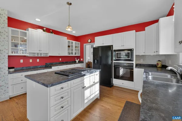a kitchen with stainless steel appliances granite countertop a stove a refrigerator and a microwave