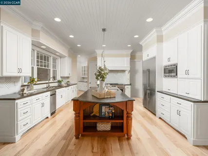 a kitchen with stainless steel appliances granite countertop a cabinets and a wooden floor