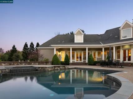 a view of house with lake view and a yard