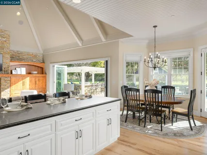 a kitchen with granite countertop white cabinets dining table and chairs