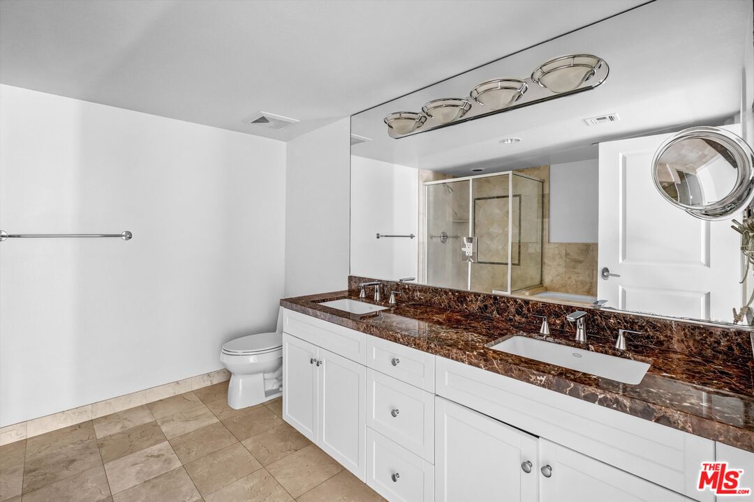 7249 Franklin Avenue, Unit 204 Los Angeles, CA 90046 - Photo 13 of 17 a bathroom with a granite countertop sink a toilet and a mirror
