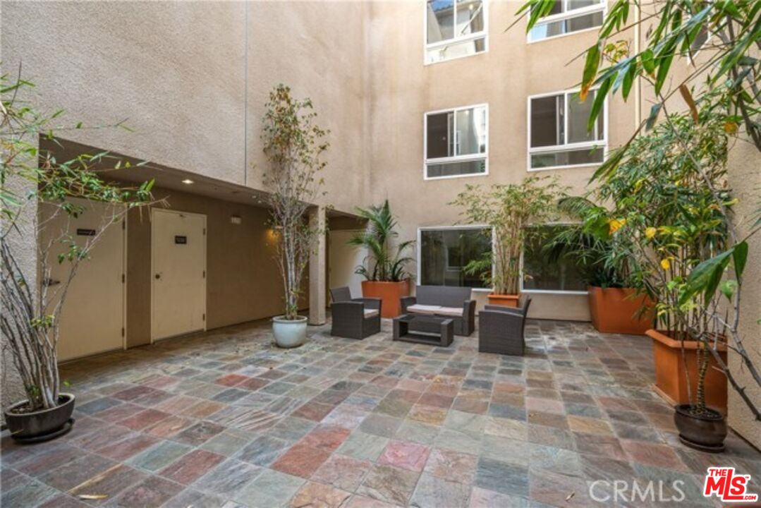 7249 Franklin Avenue, Unit 204 Los Angeles, CA 90046 - Photo 16 of 17 a view of a patio with a table and chairs and potted plants