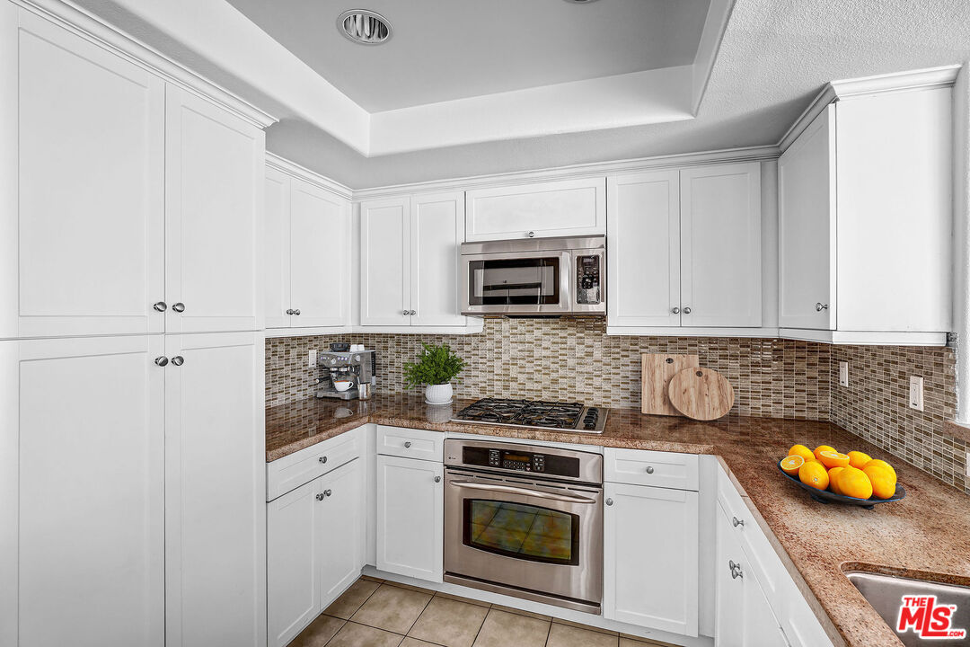 7249 Franklin Avenue, Unit 204 Los Angeles, CA 90046 - Photo 4 of 17 a kitchen with stainless steel appliances granite countertop a sink and a stove