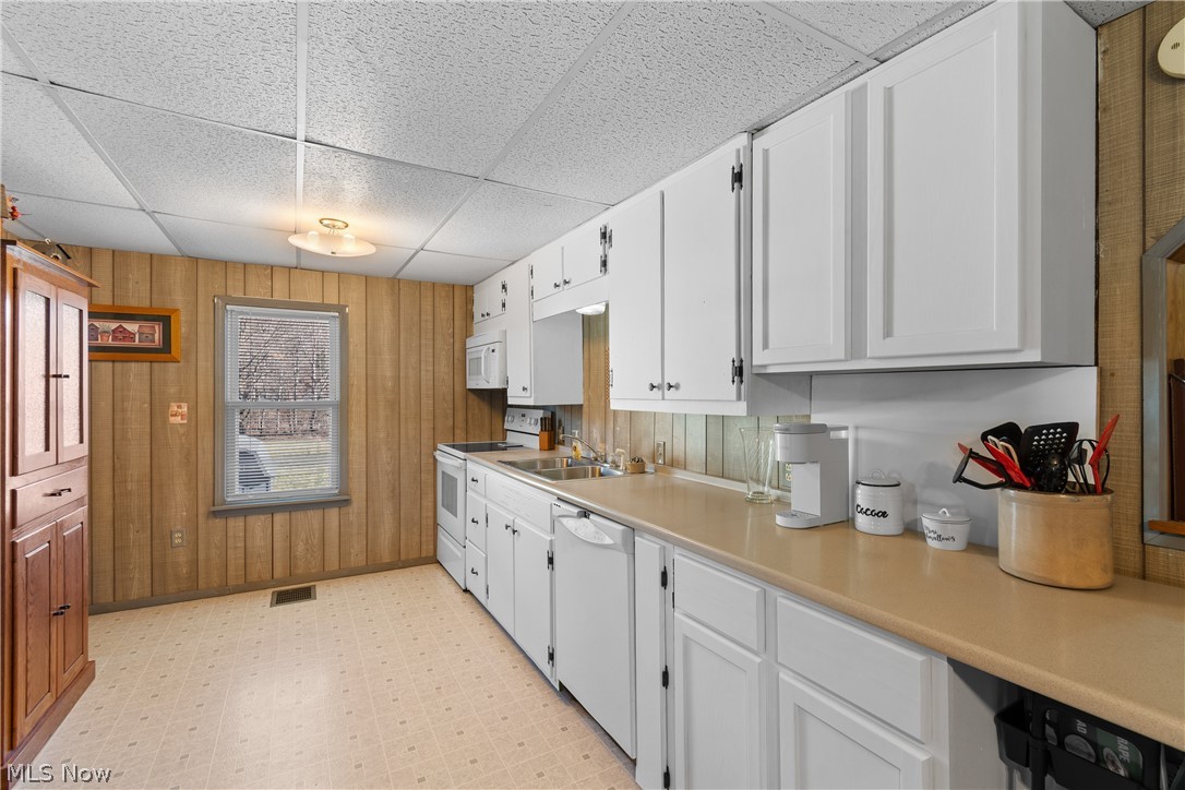 29395 Beitler Road Dennison, OH 44621 - Photo 13 of 33 Kitchen with light flooring, white appliances, white cabinetry, a drop ceiling, and light countertops