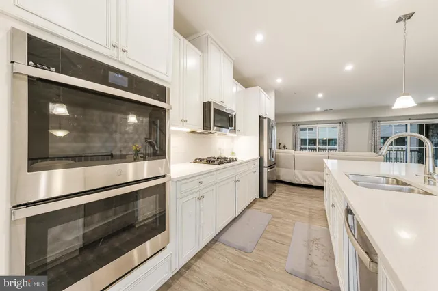 a kitchen with stainless steel appliances kitchen island granite countertop a stove a sink and a microwave