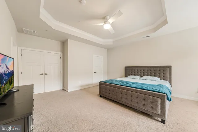 a spacious bedroom with a bed and a flat screen tv