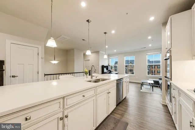 a kitchen with white cabinets appliances and wooden floor