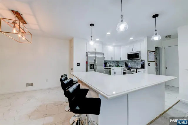 a view of kitchen with stainless steel appliances kitchen island a table and chairs