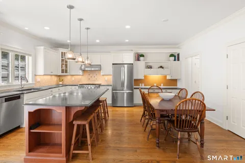 a dining table with chairs and kitchen view