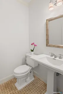 a bathroom with a sink a toilet and mirror