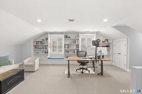 a living room with furniture and a book shelf