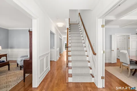 a view of a hallway with wooden floor and staircase