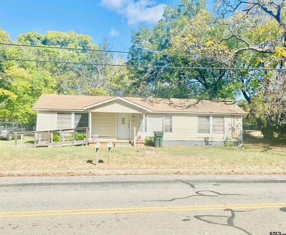 a view of a house with a yard and sitting area