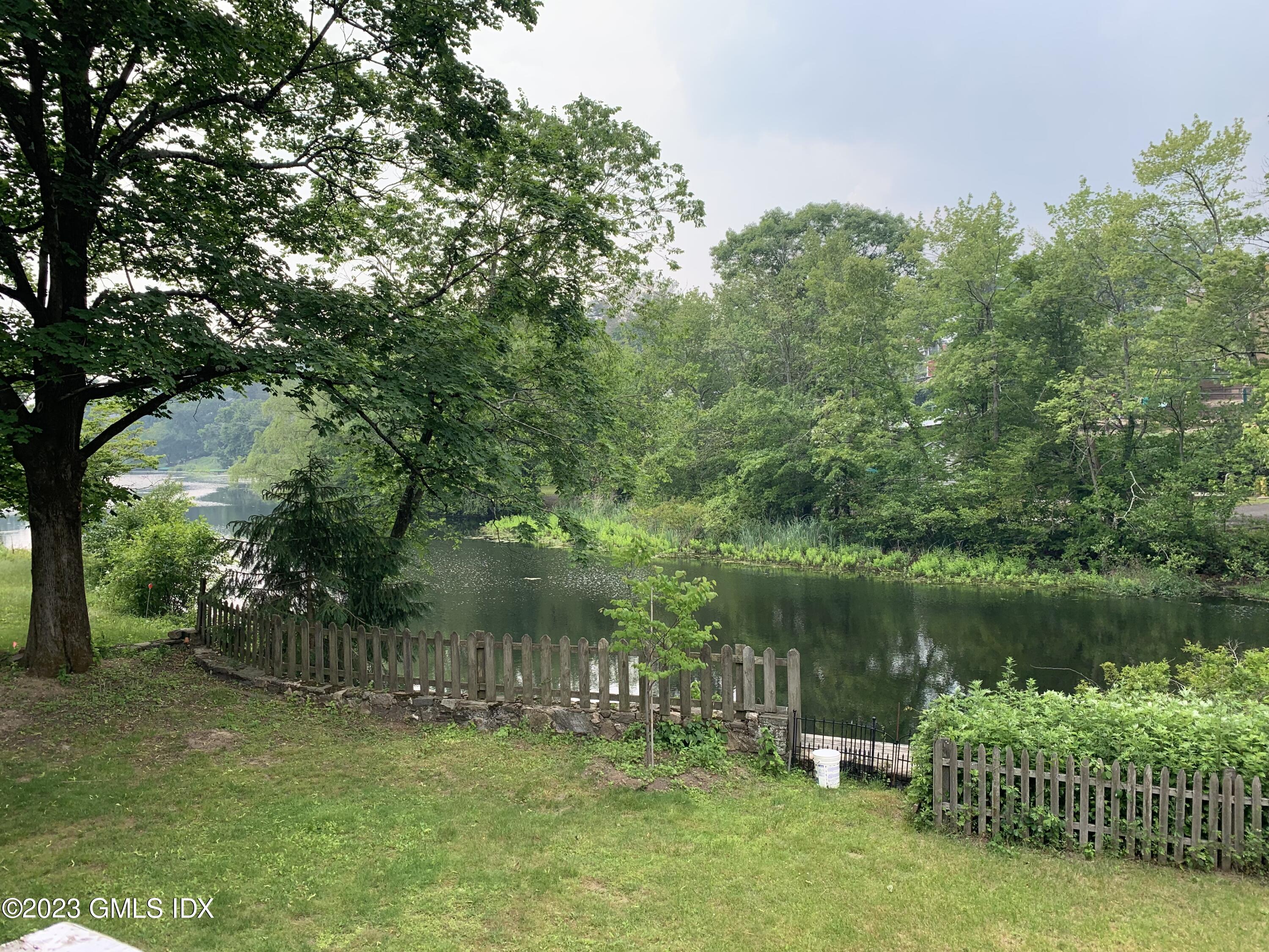 220 Sheep Hill Road, Unit 2 Riverside, CT 06878 - Photo 17 of 20 a view of a lake with a garden and trees