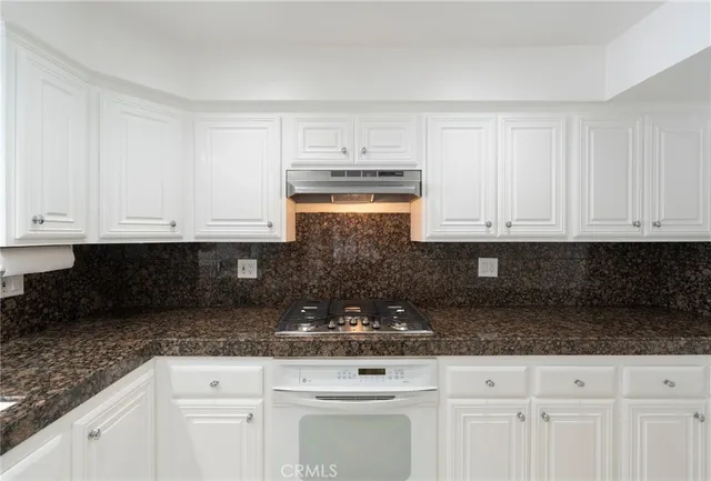 a bathroom with a granite countertop sink a mirror and shower