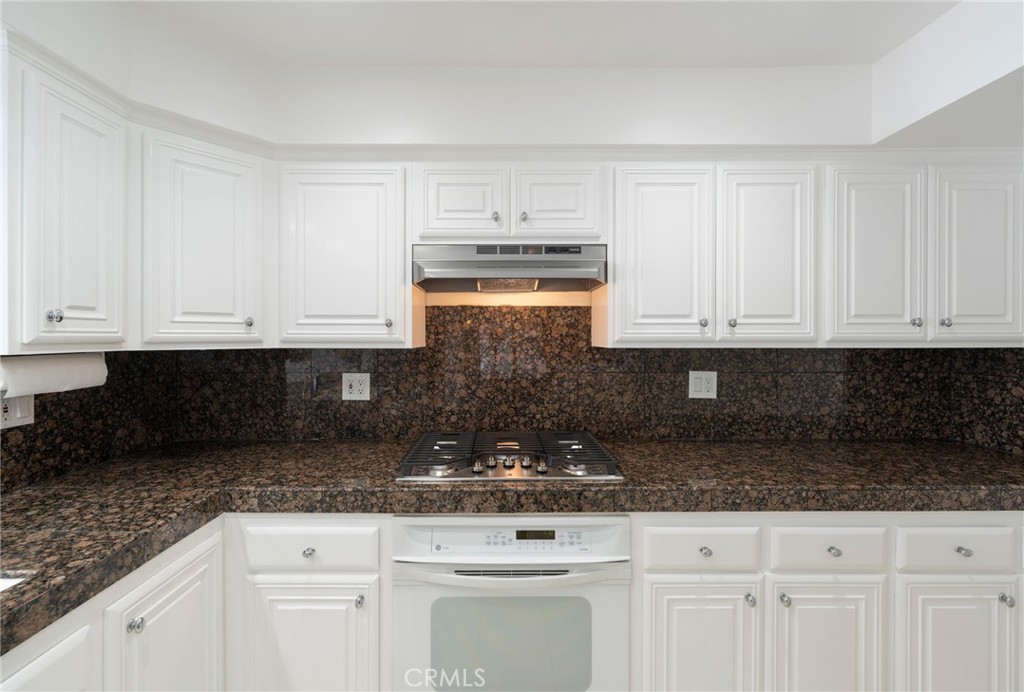 3310 Tempe Drive Huntington Beach, CA 92649 - Photo 14 of 52 a kitchen with granite countertop white cabinets and stainless steel appliances