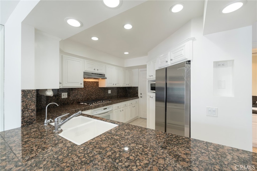 3310 Tempe Drive Huntington Beach, CA 92649 - Photo 15 of 52 a kitchen with stainless steel appliances granite countertop a sink refrigerator and cabinets