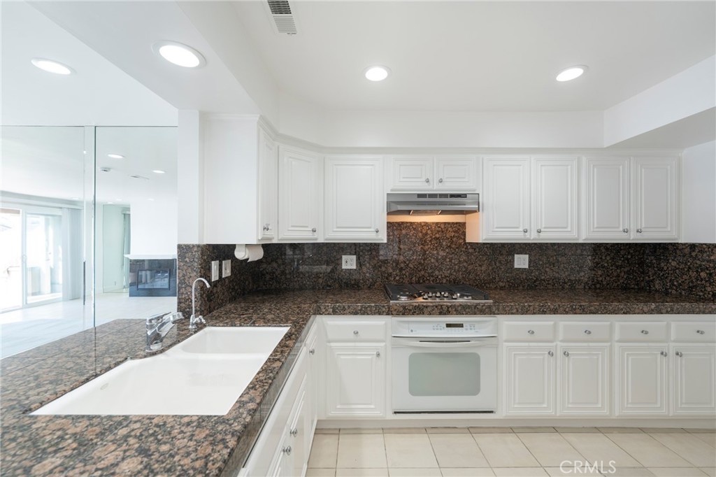 3310 Tempe Drive Huntington Beach, CA 92649 - Photo 17 of 52 a kitchen with a sink a stove and cabinets