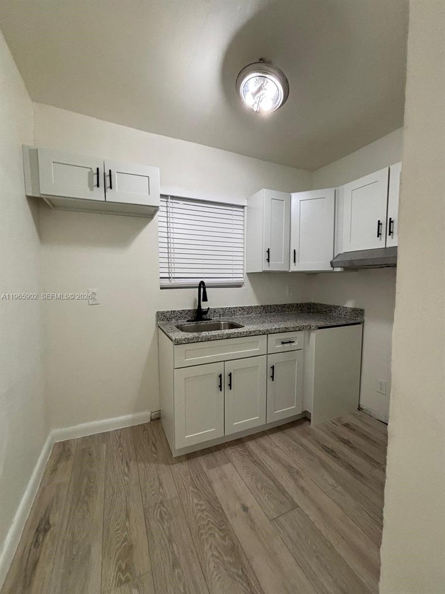 200 Northwest 13th Street, Unit 5 Miami, FL 33136 - Photo 2 of 9 a kitchen with granite countertop white cabinets and white appliances