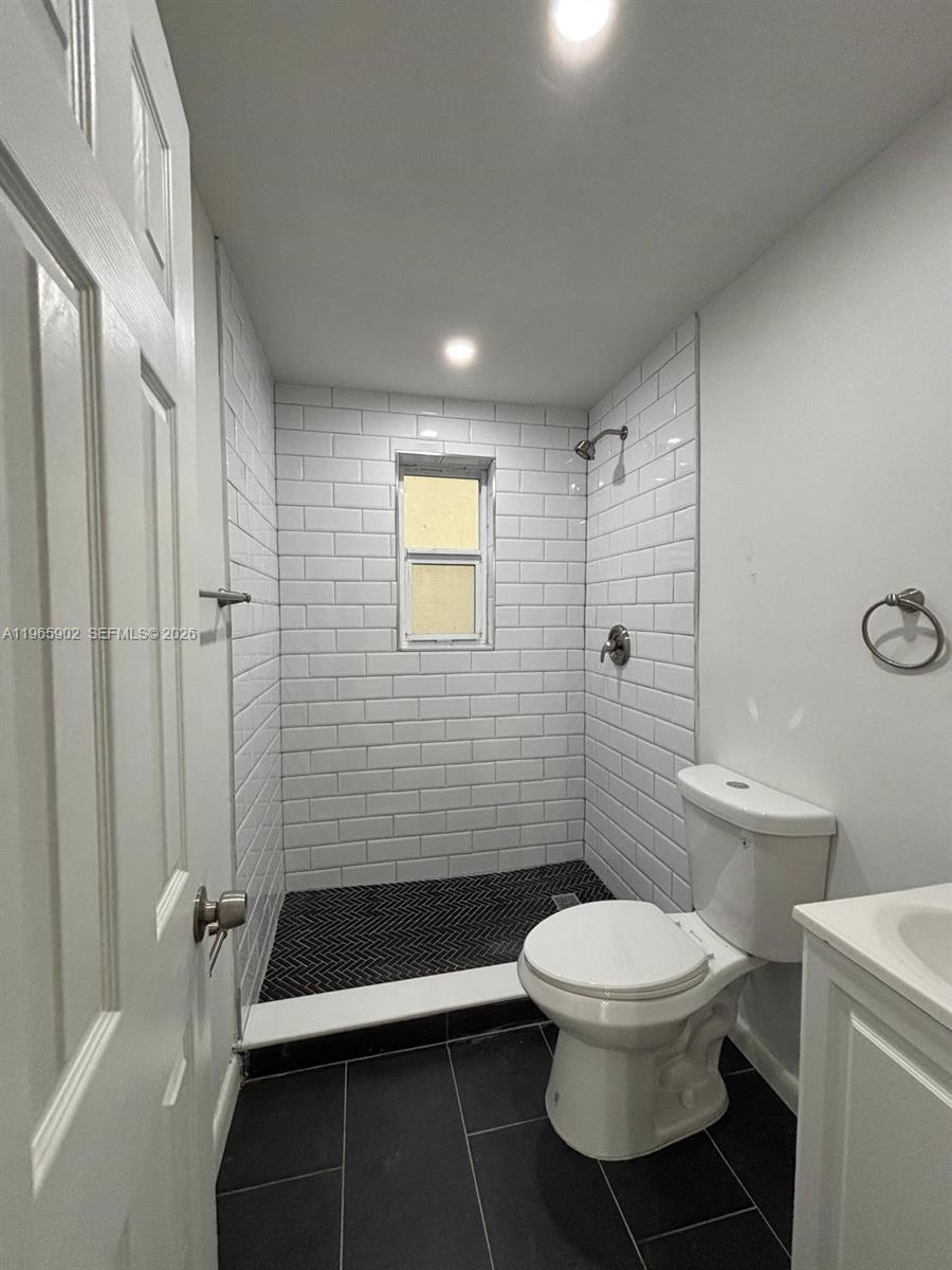 200 Northwest 13th Street, Unit 5 Miami, FL 33136 - Photo 6 of 9 a bathroom with a toilet a sink and shower
